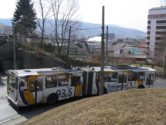 Trolejbus v reklamním hávu sjíždí ze Severní Terasy serpentinami do centra.