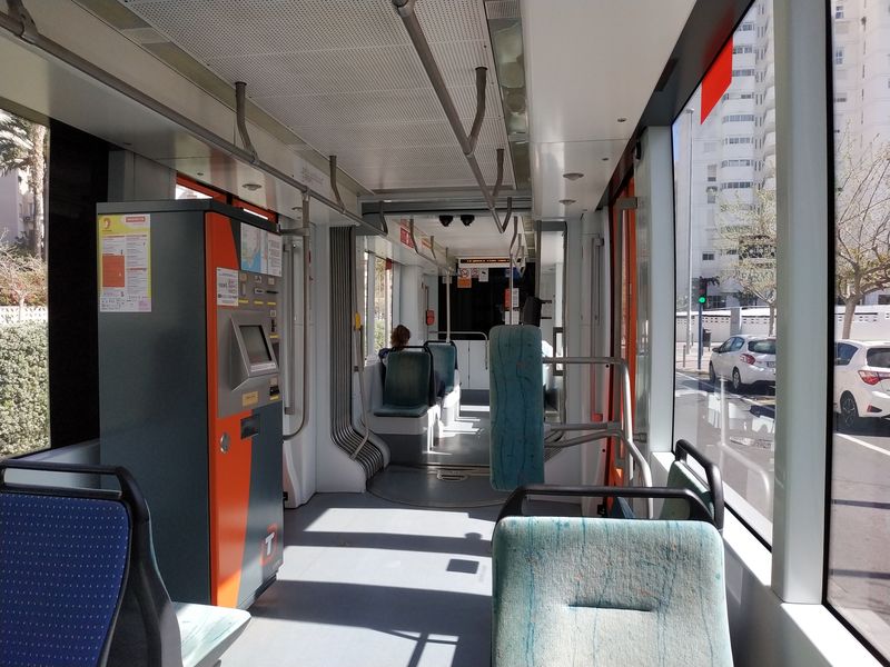 Interiér plnì nízkopodlažních tramvají Flexity Outlook od Bombardieru, kterých sem bylo postupnì dodáno 25. Stejné tramvaje jezdí také v sousední Valencii. Jízdenku si mùžete koupit až v tramvaji díky automatu a revizoøi tu chodí pomìrnì èasto.