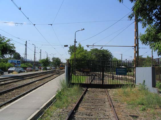 Vjezd do depa �zkoprofilov�ho metra M1. Po lev� koleji jezd� tramvaje. V��kov� rozd�l mezi trolejemi je zna�n�.