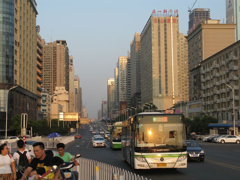 Další zástupce èínského klimatizovaného autobusu na jedné z hlavních ulic vedoucí nad linkou metra è. 2 z centra na západ pøes most pøes øeku Xiang. Moderní, ale nevzhledné centrum je plné výškových budov.