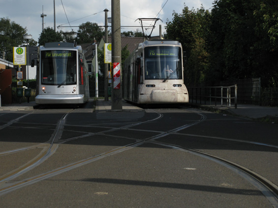 Oba dva typy nových nízkopodlažních tramvají na koneèné ve ètvrti Unterrath. Kousek dál jsou patrné zbytky staré tramvajové koneèné (kolejového pøejezdu). Atmosféru umocòují plynové lampy.