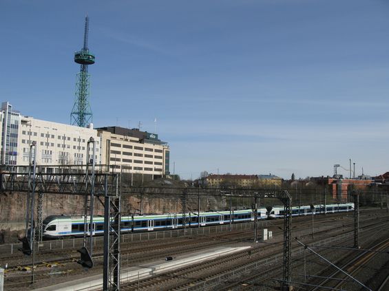 Zdvojená souprava nových jednotek Stadler pøijíždí po mohutném kolejišti do významené pøestupní stanice Pasila/Böle, která leží na severu Helsinek. U ní konèí také tramvajové linky 7 a 9.