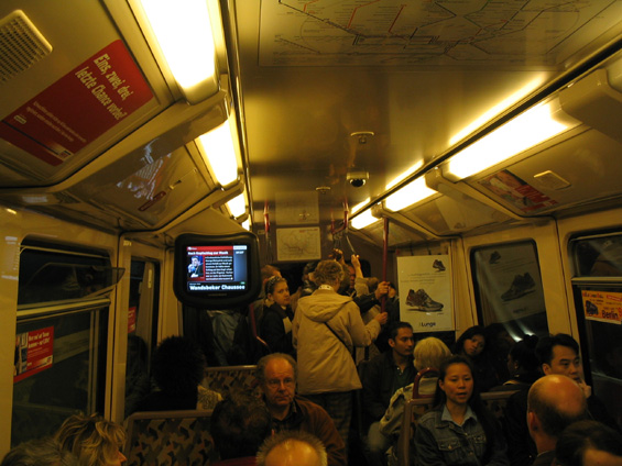 Obsazený interiér vozu metra i s ukázkou informaèních obrazovek.