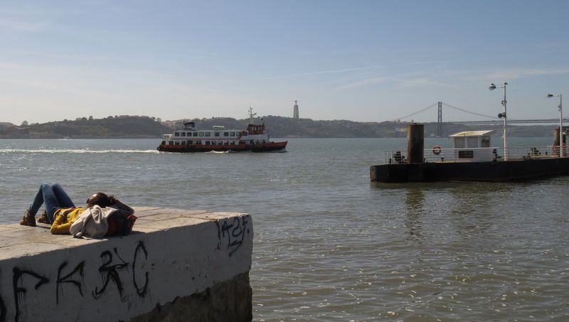 Do pøístavu Cais do Sodré míøí také lodní linky MHD z protìjšího bøehu širokého koryta øeky Tejo. V dálce je vidìt impozantní silniènì-železnièní most tamtéž. Za øekou už není Lisabon, ale samostatné mìsto Almada.