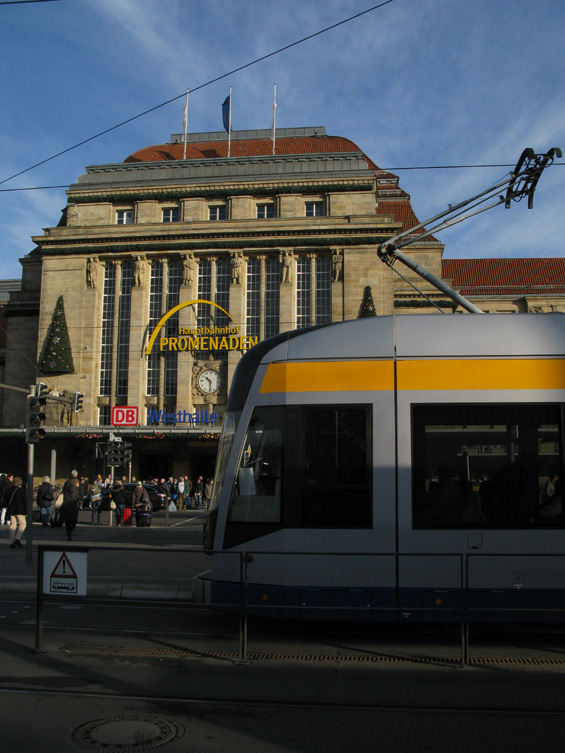 První série lipských nízkopodlažních tramvají typu NGT8 pøed budovou hlavního nádraží. Pøechod pøes pøednádražní tøídu je velmi rušný.
