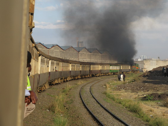 Ranní dìlnický devatenáctivozový vlak pøijíždí do Nairobi. V posledních zastávkách už je ve vlaku velmi tìsno, stojí se, kde se dá. Dieselová lokomotiva není v nejlepší kondici, šlehající plameny z výfuku na støeše a ohlušující zvuk motorù umocòují nezapomenutelný zážitek z asi hodinové jízdy, která nás stála v pøepoètu cca 10 Kè.
