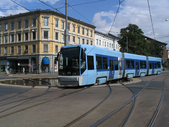 Zøejmì nejnovìjší typ tramvaje v Oslu právì pøejíždí køižovatku s fontánou, která pøi prùjezdu tramvaje automaticky utichá.