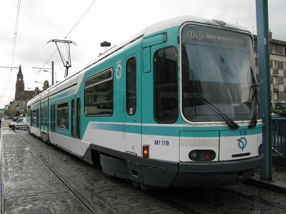 Detail èásteènì nízkopodlažní tramvaje Alstom na lince T1 ve ètvrti St. Denis na sever od Paøíže. Vedení linky T1 je uèebnicovými pøíkladem, jak lze tramvaj citlivì zakomponovat do již vzrostlého mìsta.