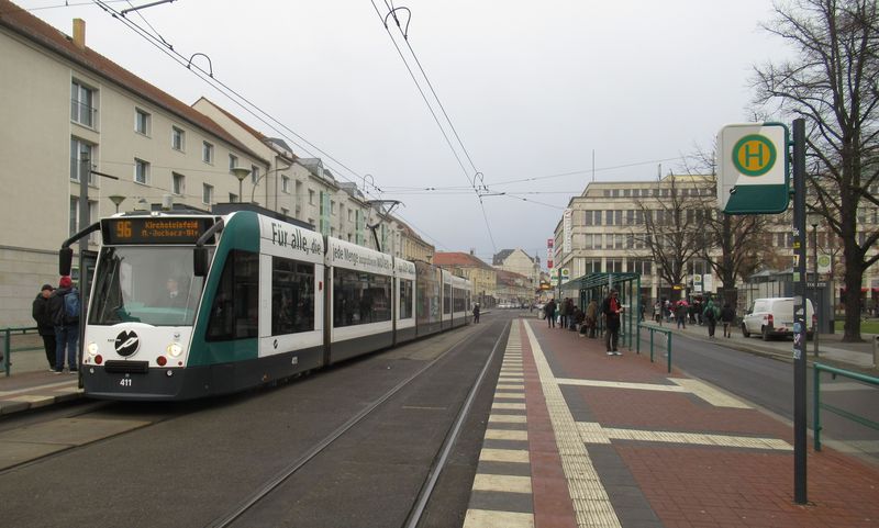 Další prodloužené Combino na centrální pøestupní zastávce Platz der Einheit i s propagaèním nápisem na boku. Nejstarší tramvaje tohoto typu jsou staré už 22 let. Prototyp Combina z roku 1996 nyní slouží k testování automatického provozu bez øidièe.