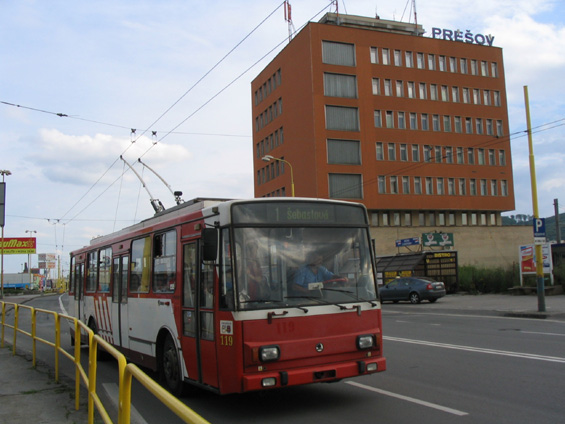 Standardní trolejbus projíždí kolem budovy prešovského vlakového nádraží.