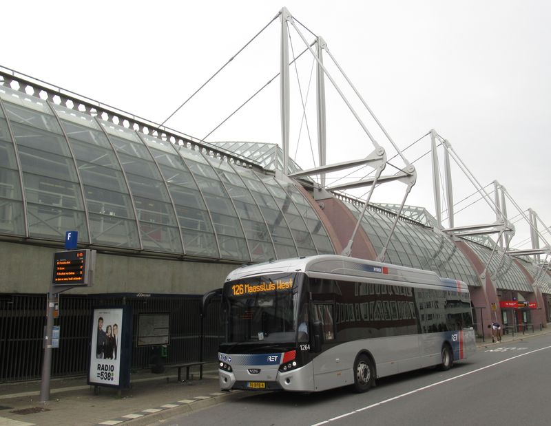 Další hybridní VDL Citea u vlakového nádraží Schiedam v západní èásti mìsta. V letech 2019 a 2021 poøídit místní dopravní podnik RET necelou stovku již plnì elektrických autobusù VDL. Ve své flotile má od roku 2017 dva vodíkové tøínápravové autobusy VanHool.