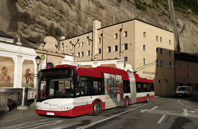 Jeden z prvních kloubových trolejbusù Solaris ještì v klasické karoserii z roku 2020 na lince 10 v centru Salcburku. Podle reklamy na boku také zde intenzivnì hledají nové øidièe.
