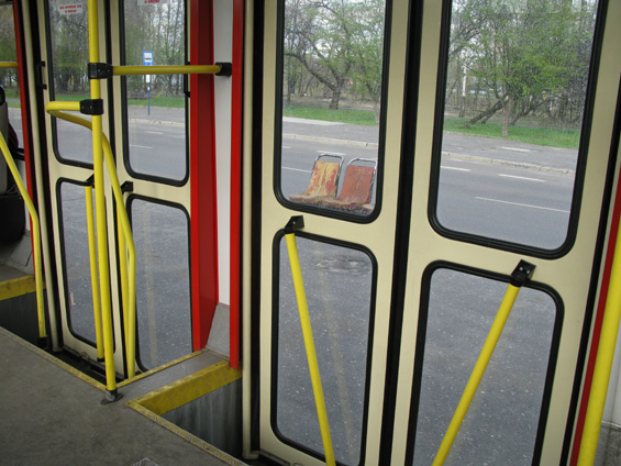 Detail dvojitých støedních dveøí - typického prvku tramvají Konstal 105N. Za dveømi mùžete venku vidìt laminátové sedaèky z tohoto typu tramvaje použité jako lavièky na zastávce.