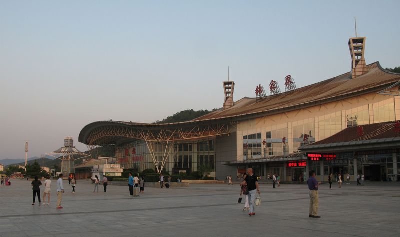 Velkorysá hala vlakového nádraží v jižní části města na úpatí národního parku Tianmen, kam vede okolo nádražní budovy kabinová lanovka. Konvenční železnice je však velmi pomalá (z nejbližšího velkého města Changsha sem trvá cesta cca 7 hodin), proto se již i sem staví vysokorychlostní železnice, která bude mít nádraží východně od města a která povede díky velmi členitému terénu po většinu své trasy buď tunelem nebo po estakádě.